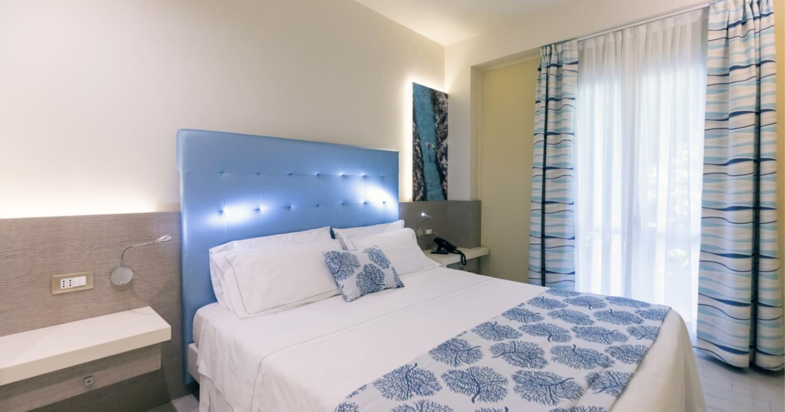 Bright room with double bed and blue decorations.