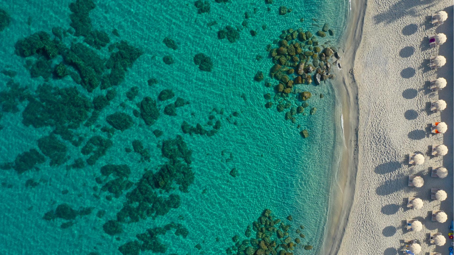 Spiaggia con ombrelloni e mare cristallino.