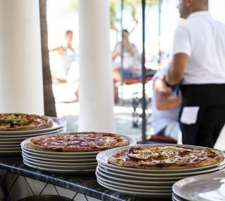 Pizze su piatti impilati in un ristorante all'aperto.