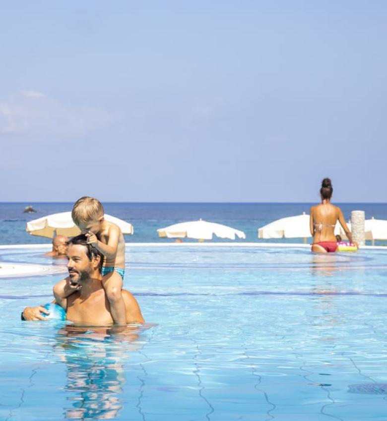 Famiglia si diverte in piscina con vista mare.