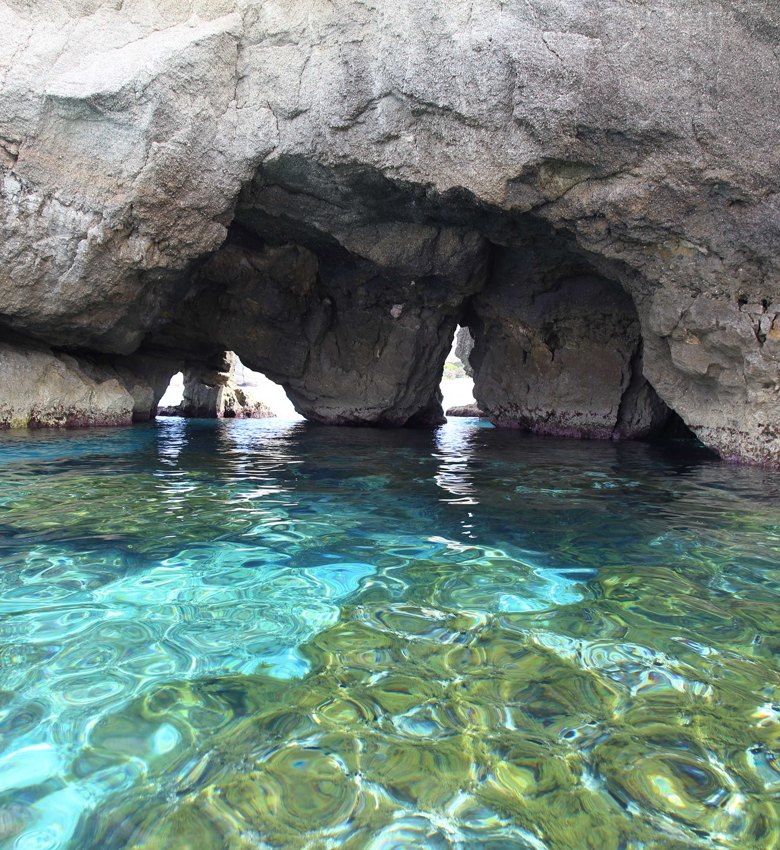 Grotta marina con acqua cristallina e riflessi di luce suggestivi.