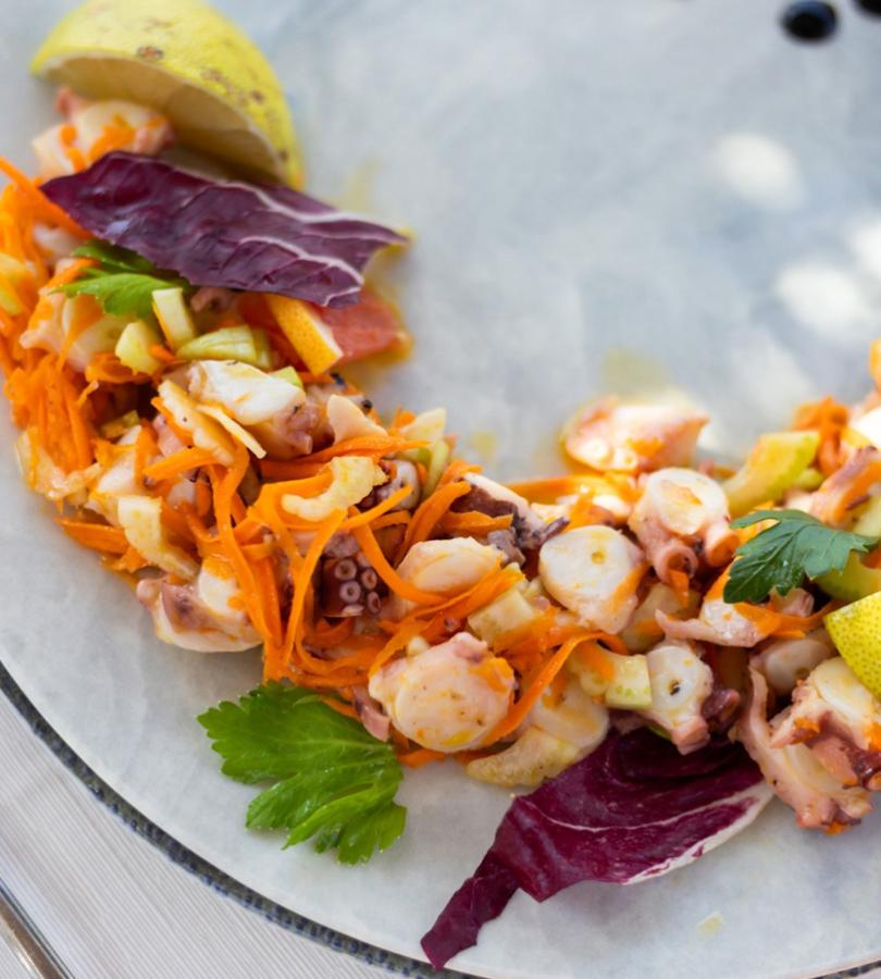 Seafood salad with octopus, carrots, and lemon.